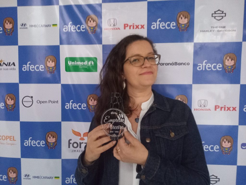 Flávia Alves, analista financeira recebendo o Prêmio Empresa Parceira da Afece