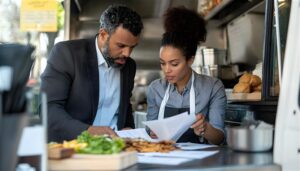 businessman-woman-reviewing-documents-food-truck