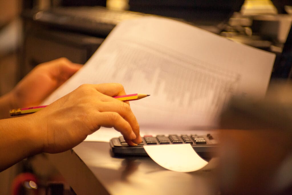 maos-cortadas-de-um-empresario-usando-uma-calculadora-na-mesa-no-escritorio